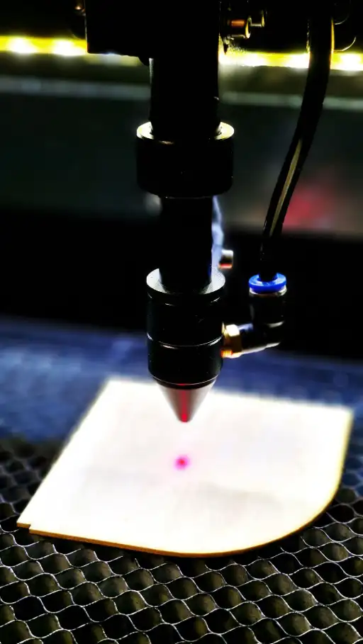 Focus du Laser, bois de tilleul clair Zoom sur la machine de decoupe laser et de l'epaisseur du bois brut, choix de l'essence du materiaux, dans l'atelier Arkitorii